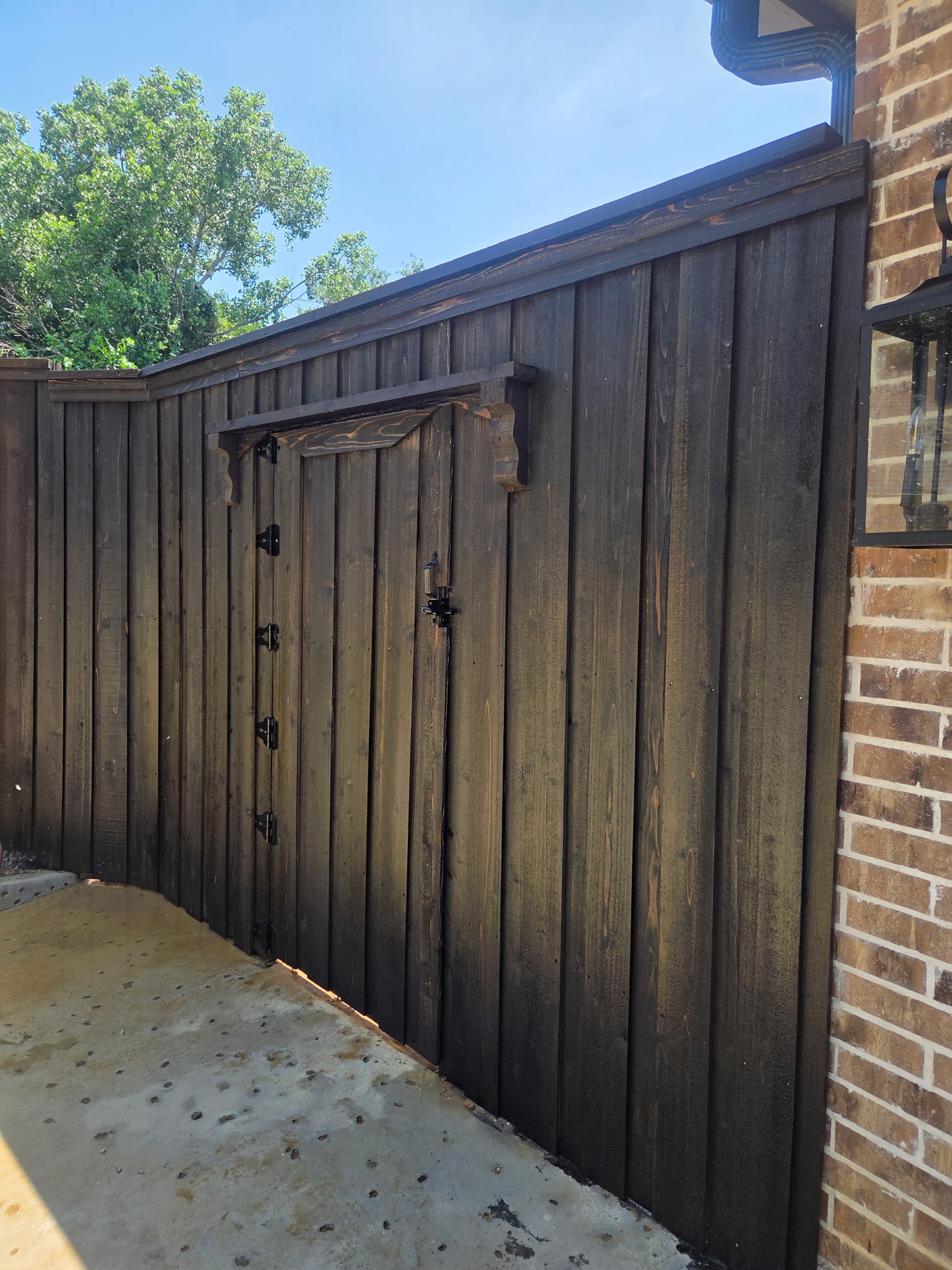 Dark stained wood fence with custom gate